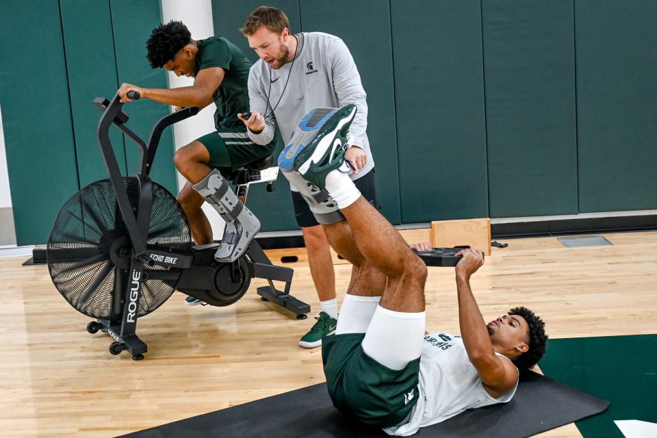 Michigan State's Jaden Akins left, and Malik Hall, right, work with associate strength and conditioning coach Marshall Repp during the first day of practice on Monday, Sept. 26, 2022, at the Breslin Center in East Lansing.