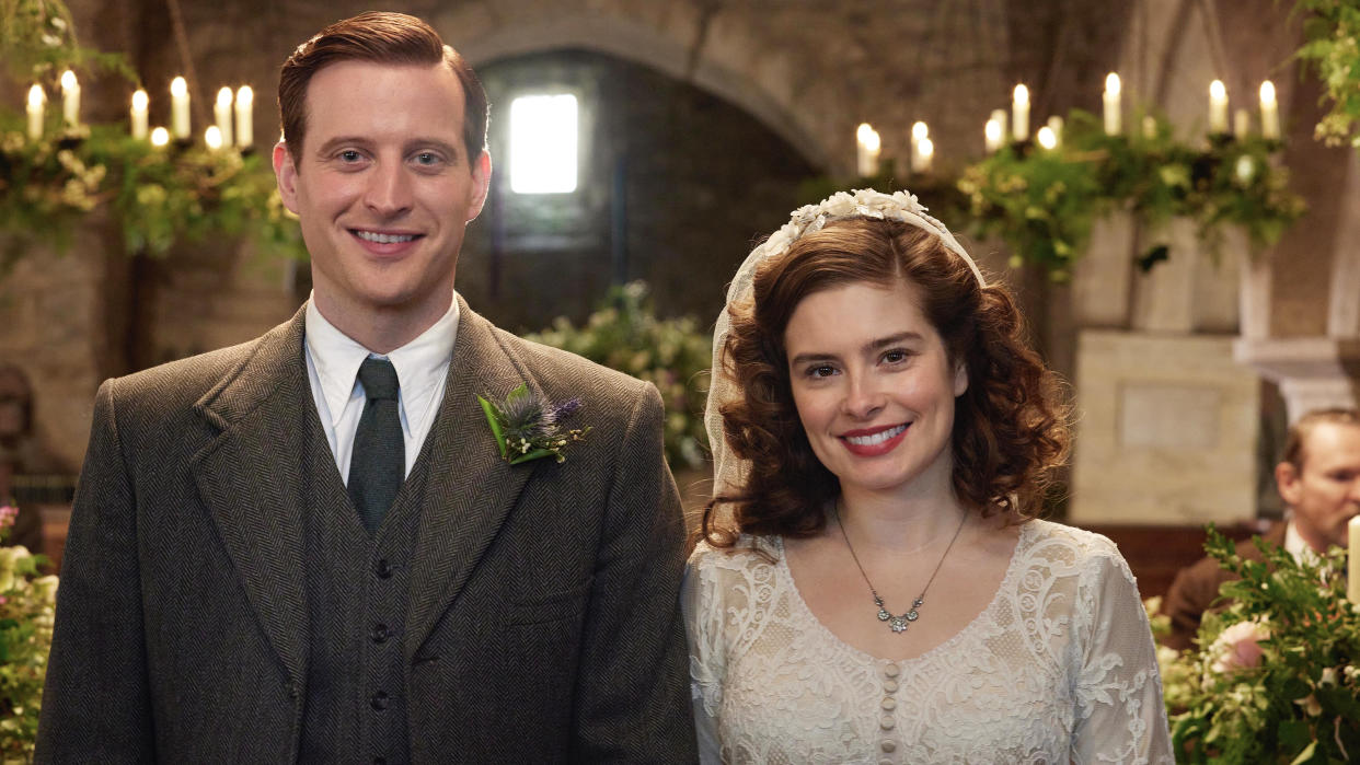  Nicholas Ralph as James in a tweed suit and tie and Rachel Shenton as Helen in a wedding dress in the church in All Creatures Great and Small. 