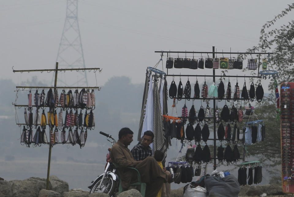 Pakistani vendors selling face masks wait for customers as heavy smog blankets Lahore, Pakistan, Thursday, Nov. 21, 2019. Amnesty International issues "Urgent Action" saying every person in Lahore at risk. Heavy smog has enveloped many cities of Punjab province, causing highway accidents and respiratory problems, and forcing many residents to stay home. (AP Photo/K.M. Chaudary)