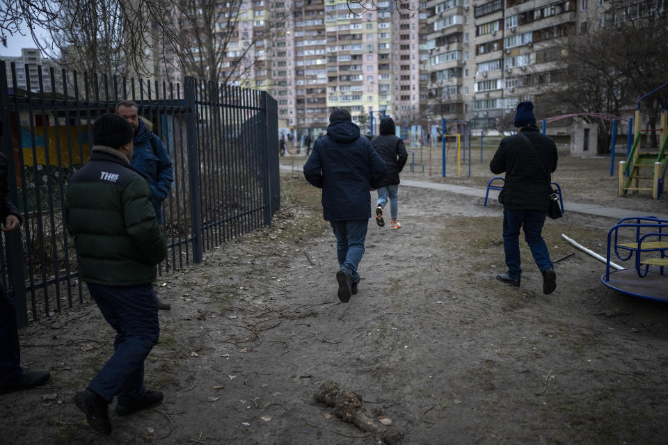 People run to take shelter while the sirens sound announcing new attacks in the city of Kyiv, Ukraine, Friday, Feb. 25, 2022. (AP Photo/Emilio Morenatti)