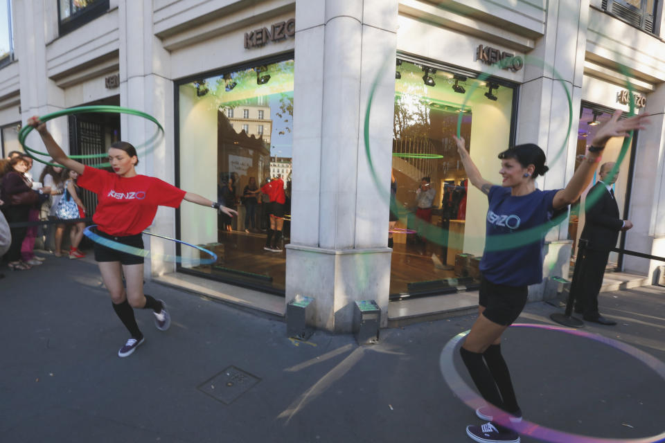 Fashion models perform with hula hoops in the streets of Paris, Thursday Sept. 6 2012, during Fashion's Night Out where fashion shops open their doors at night to encourage consumers to support the fashion industry. (AP Photo/Jacques Brinon)