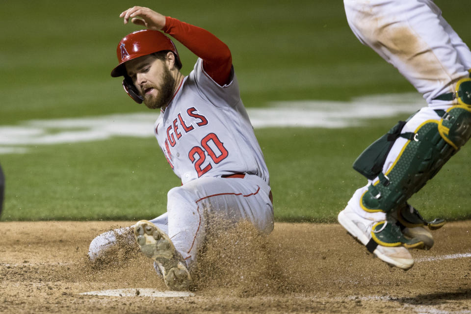 Los Angeles Angels' Jared Walsh (20) slides home to score against the Oakland Athletics during the seventh inning of a baseball game in Oakland, Calif., Monday, June 14, 2021. (AP Photo/John Hefti)