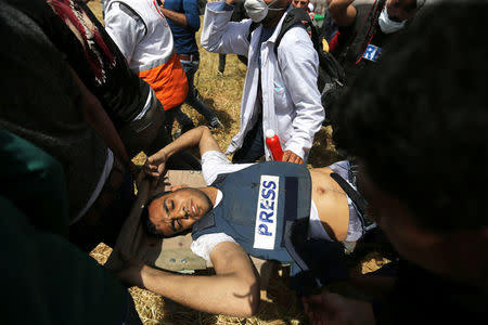 Mortally wounded Palestinian journalist Yasser Murtaja, 31, is evacuated during clashes with Israeli troops at the Israel-Gaza border, in the southern Gaza Strip April 6, 2018. REUTERS/Ibraheem Abu Mustafa