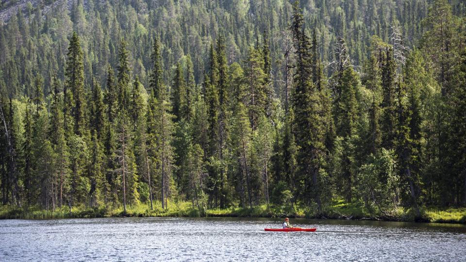 A canoeist paddles on the Kesanki Lake in Akaslompolo, Kolari in Lapland, Northern Finland