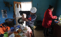 Gracce Kelly Flores, a 12-year-old boxer who goes by the nickname Hands of Stone, fills breakfast cups with boiled water for hot chocolate as she helps prepare breakfast for her family, after her daily boxing workout in Palca, Bolivia, early Thursday, June 10, 2021, amid the COVID-19 pandemic. At age 8, Flores defeated a 10-year-old boy, and with three national boxing medals under her belt, she dreams of reaching the women's boxing world championship. (AP Photo/Juan Karita)