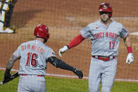 Cincinnati Reds' Kyle Farmer (17) is congratulated by Tucker Barnhart as Farmer returns to the dugout after hitting a solo home run off Pittsburgh Pirates relief pitcher Sam Howard during the eighth inning of a baseball game in Pittsburgh, Wednesday, Sept. 15, 2021. (AP Photo/Gene J. Puskar)