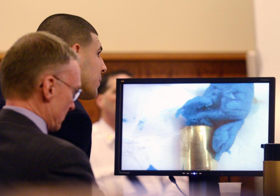 Former New England Patriots tight end Aaron Hernandez with attorney Charles Rankin view an image of the bubble gum and the bullet shell on the screen during his murder trial at Bristol County Superior Court in Fall River, Massachusetts, April 6, 2015. REUTERS/Ted Fitzgerald/Pool