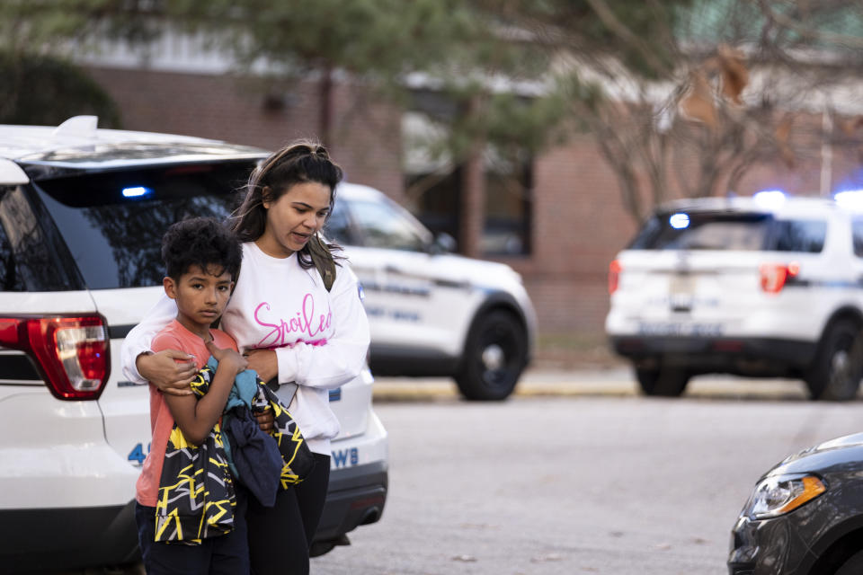 Carlos Glover, age 9, a fourth grader at Richneck Elementary School, is held by his mother Joselin Glover as they leave the school, Friday, Jan. 6, 2023 in Newport News, Va. A shooting at a Virginia elementary school sent a teacher to the hospital and ended with “an individual” in custody Friday, police and school officials in the city of Newport News said.(Billy Schuerman/The Virginian-Pilot via AP)