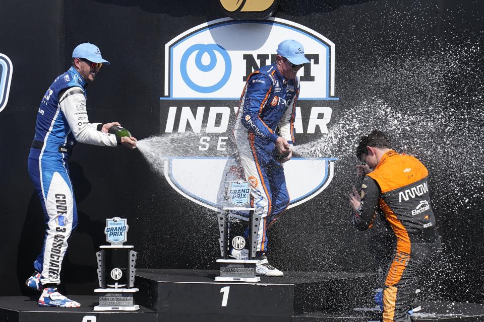 Scott Dixon, middle, of New Zealand, Graham Rahal, left, and Pato O'Ward, of Mexico, celebrate after the IndyCar Indianapolis GP auto race at Indianapolis Motor Speedway, Saturday, Aug. 12, 2023, in Indianapolis. Dixon won the race, Rahal finished second and O'Ward was third. (AP Photo/Darron Cummings)