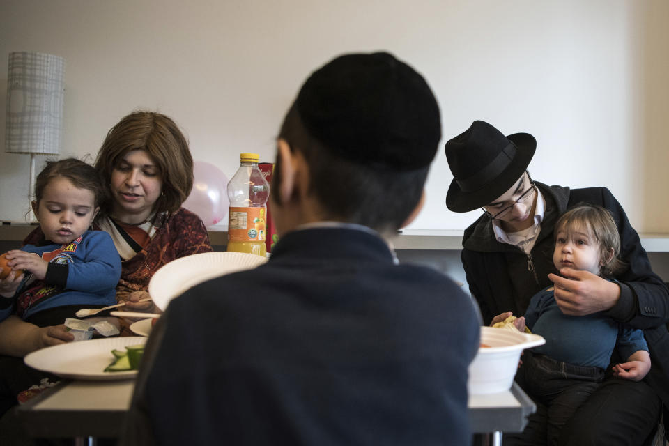 Children and their companions from an orphanage in Odesa, Ukraine, eat after their arrival at a hotel in Berlin, Friday, March 4, 2022. More than 100 Jewish refugee children who were evacuated from a foster care home in war-torn Ukraine and made their way across Europe by bus have arrived in Berlin. (AP Photo/Steffi Loos)