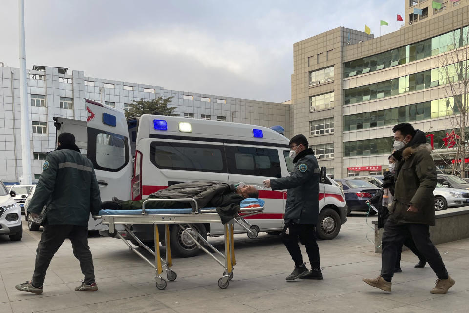 Medical workers push a man past an ambulance at the Baoding No. 2 Central Hospital in Zhuozhou city in northern China's Hebei province on Wednesday, Dec. 21, 2022. China only counts deaths from pneumonia or respiratory failure in its official COVID-19 death toll, a Chinese health official said, in a narrow definition that limits the number of deaths reported, as an outbreak of the virus surges following the easing of pandemic-related restrictions. (AP Photo)