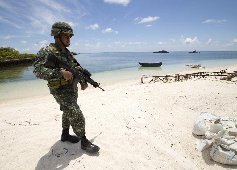 A Philippine soldier patrols a beach on Pagasa Island in the Spratly group of islands in the South China Sea on May 11, 2015