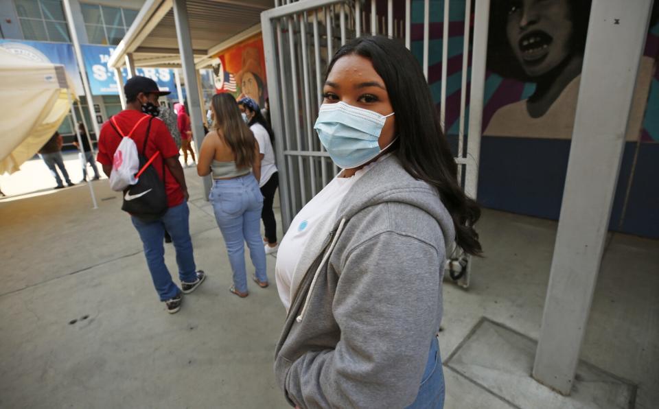 Socially-distanced students wait to enter campus