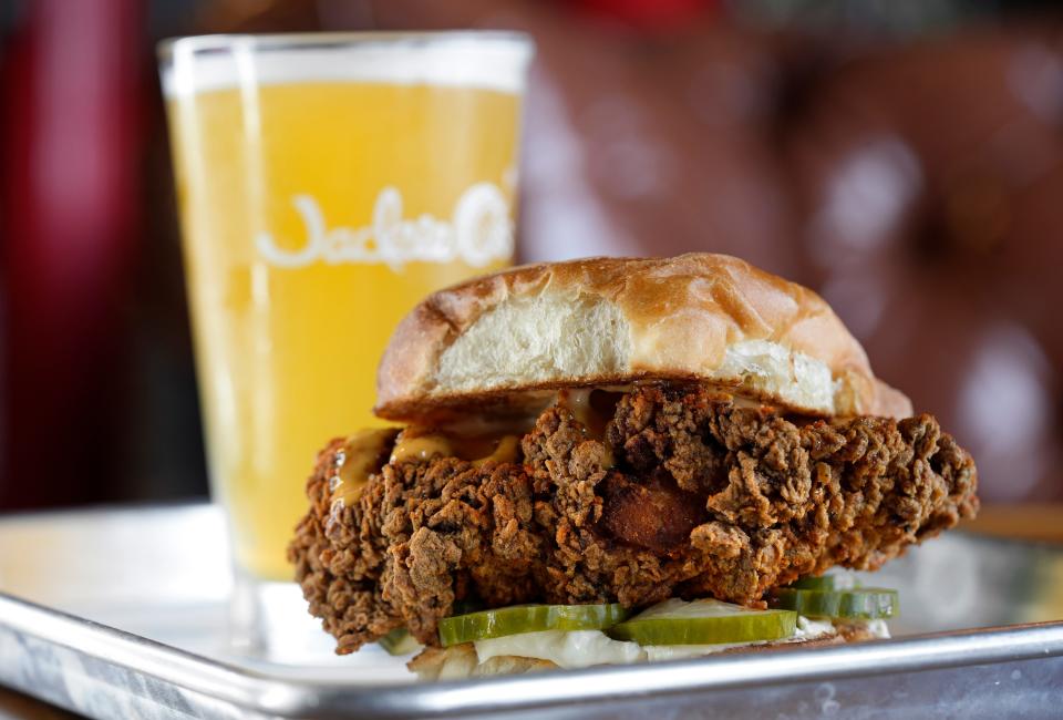 Sept. 13, 2023; Columbus, Oh., USA; 
The Ol Faithful spicy chicken sandwich and a pint of Jackie O's Sun Shimmer hazy IPA beer from Goood Friends inside Jackie O's in downtown Columbus.