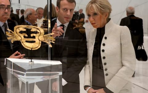 Emmanuel Macron and his wife Brigitte look at a piece of art as they visit the Louvre Abu Dhabi Museum in Abu Dhabi - Credit:  REUTERS