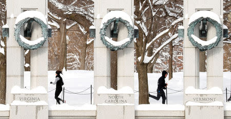 Joggers pass one another, following the weekend's snowstorm, at the World War II Memorial in Washington, U.S., January 14, 2019. REUTERS/Kevin Lamarque