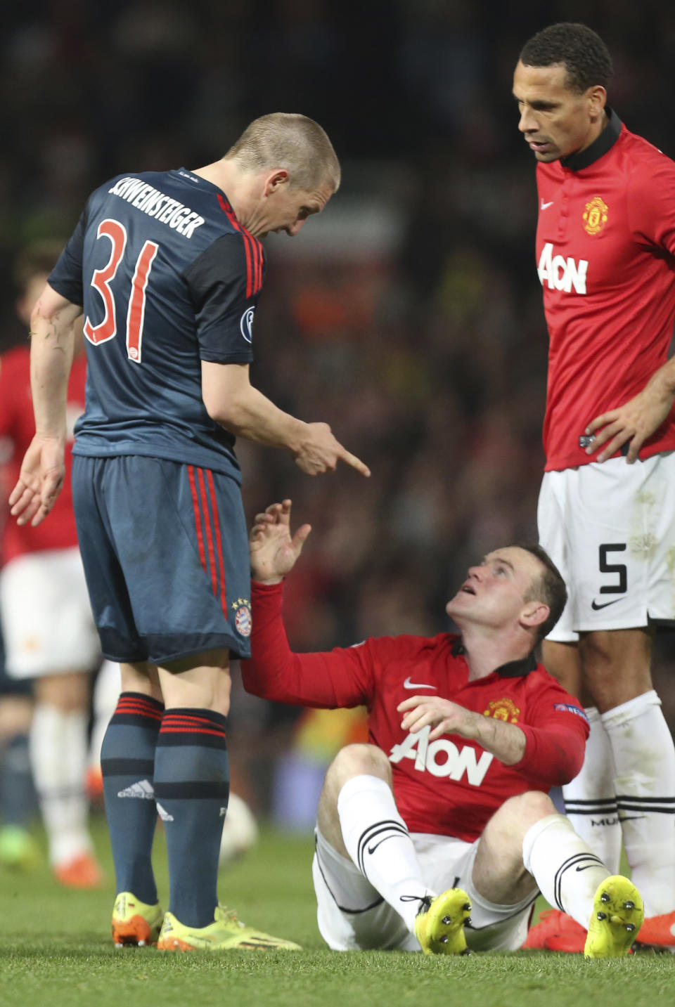 Bayern's Bastian Schweinsteiger, left, argues with Manchester United's Wayne Rooney, bottom, after he was sent off the field during the Champions League quarterfinal first leg soccer match between Manchester United and Bayern Munich at Old Trafford Stadium, Manchester, England, Tuesday, April 1, 2014.(AP Photo/Jon Super)