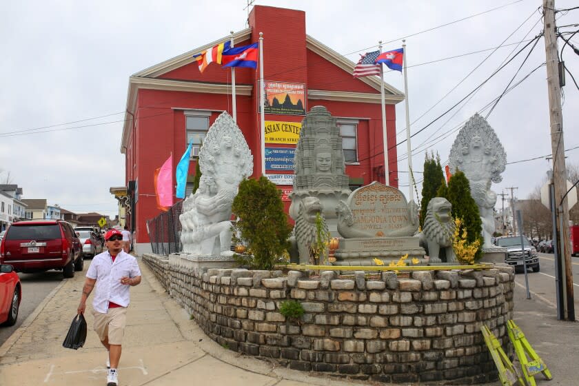 A man walks past by statues representing Cambodian culture at Lowell, MA, 23 April 2022.