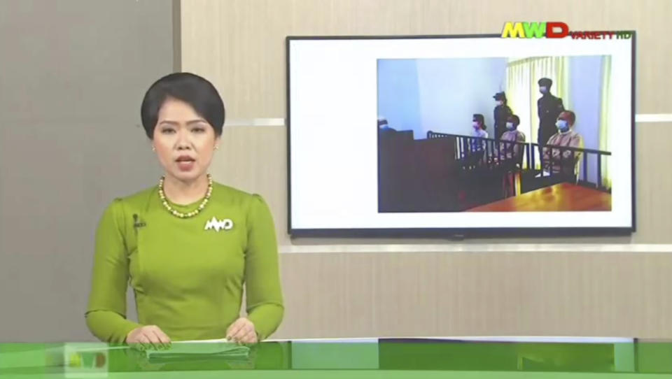 In this image from Myawaddy TV, a photograph of deposed Myanmar leader Aung San Suu Kyi's court appearance was shown during a report about her case is read by a news presenter Monday, May 24, 2021, in Naypyitaw, Myanmar. Myanmar’s ousted leader Aung San Suu Kyi has made a court appearance in person for the first time since the military arrested her Feb. 1. (Myawaddy TV via AP)