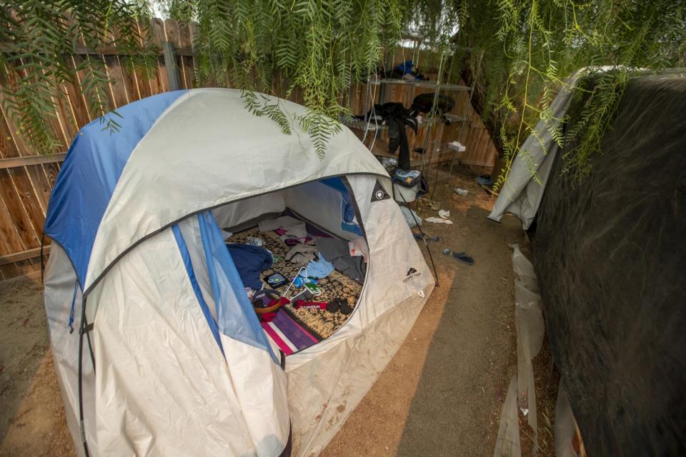 A tent and debris at the property where seven people were shot to death.