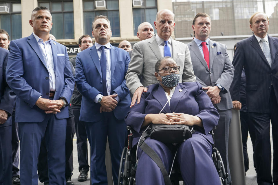 Retired NYPD Detective Barbara Burnette, foreground, who worked on the World Trade Center pile for 23 days after the terrorist attacks in 2001 is joined by her attorney Nicholas Papain, third from right, and former New York Gov. George Pataki, right, and other 9/11 first responders during a news conference, Wednesday, Sept. 8, 2021, in New York. (AP Photo/Mary Altaffer)