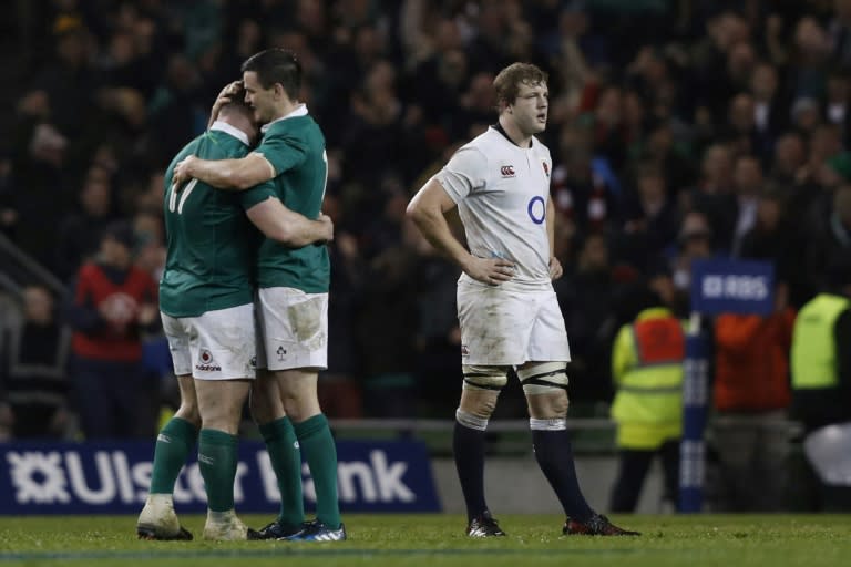 Ireland's Cian Healy (L) and fly-half Johnny Sexton embrace as England's lock Joe Launchbury (R) reacts at the final whistle in the Six Nations international rugby union match March 18, 2017