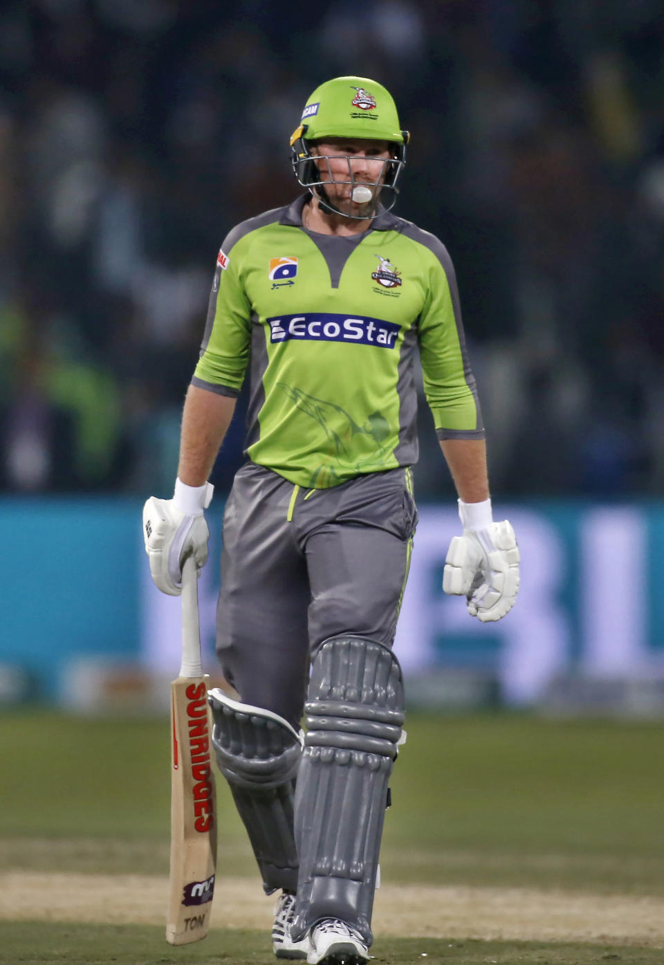 In this Sunday, March 8, 2020 photo, Lahore Qalandars batsmen Ben Dunk walks during a Pakistan Super League T20 cricket match against Karachi Kings, in Lahore, Pakistan. A bubble chewing bald Australian batsman has suddenly become an instant hit in the Pakistan Super League Twenty20 tournament. Dunk broke his own record of most sixes in a PSL game within a week when he smashed 12 towering sixes against Karachi Kings in a blistering knock of unbeaten 99 off just 40 balls on Sunday night. (AP Photo/K.M. Chaudary)