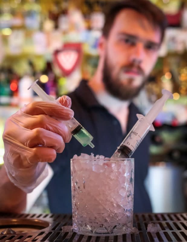 A barman stirs the new cocktail "Coronavirus" in a bar in Moscow