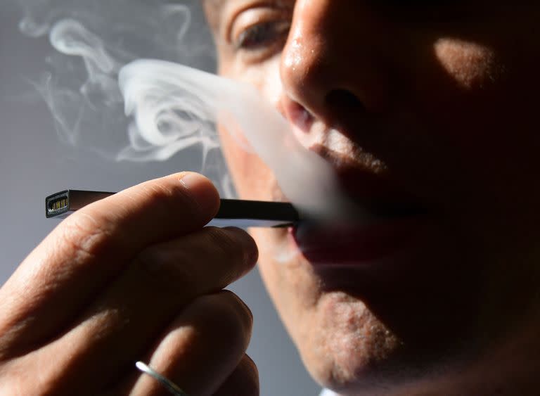 (FILES) In this file illustration taken on October 02, 2018, a man exhales smoke from an electronic cigarette in Washington, DC. - The US Food and Drug Administration on June 23, 2022 said it was ordering all vaping products produced by Juul Labs off the market after finding the former industry leader had failed to address certain safety concerns. (Photo by EVA HAMBACH / AFP)