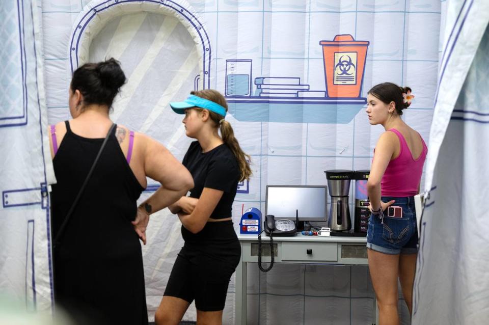 Tiffany Richey, left, and daughters Makayla, 13, right, and Miley, 10, work on the solving science puzzles in the VENOMventure escape room at the Modesto Library in Modesto, Calif., Saturday, June 24, 2023.