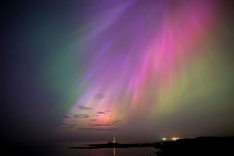 The aurora borealis, also known as the northern lights, glow on the horizon at St. Mary's Lighthouse in Whitley Bay on the North East coast, England, Friday, May 10, 2024.
