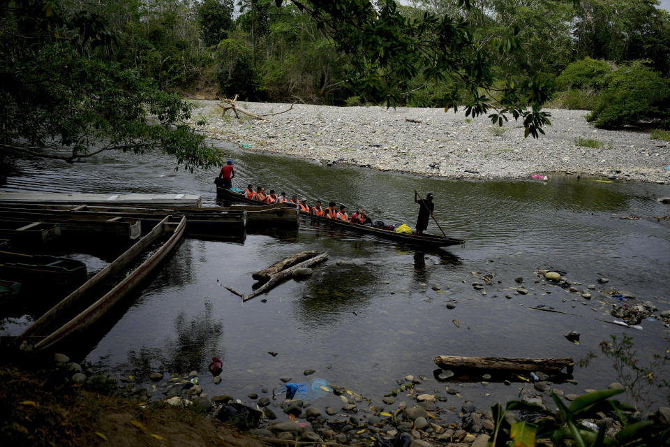 Migrants ride on a boat along the Membrillo River en route to Canaan Membrillo, Panama, after walking across the Darien Gap from Colombia, Sunday, May 7, 2023. (AP Photo/Natacha Pisarenko)