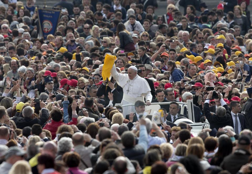 Pope Francis holds up a scarf as he arrives for his weekly general audience in St. Peter's Square at the Vatican, Wednesday, April 2, 2014. (AP Photo/Alessandra Tarantino)