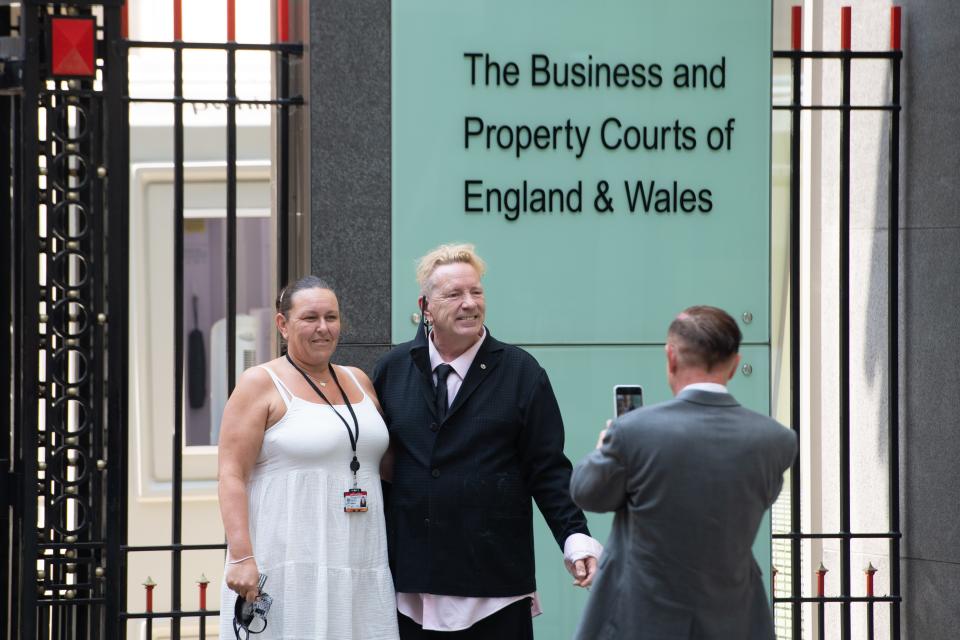 John Lydon, centre, poses for a photo outside the Rolls Building at the High Court (Dominic Lipinski/PA) (PA Wire)