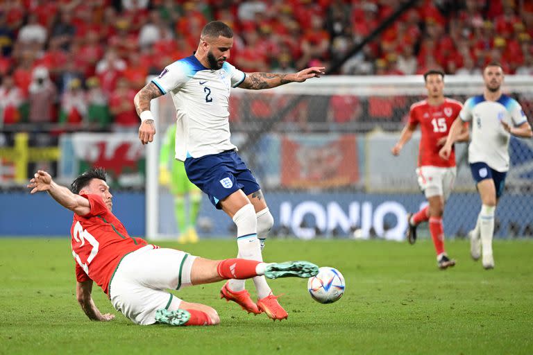 Wales' forward #13 Kieffer Moore (L) tackles England's defender #02 Kyle Walker (R) during the Qatar 2022 World Cup Group B football match between Wales and England at the Ahmad Bin Ali Stadium in Al-Rayyan, west of Doha on November 29, 2022. (Photo by Ina Fassbender / AFP)