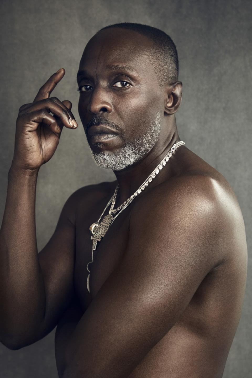 Michael K. Williams, photographed shirtless, in partial profile, looking directly at the camera.