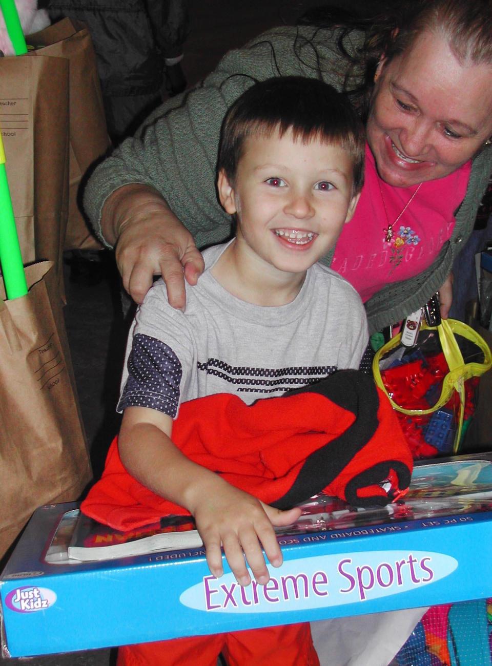 Six-year-old Devin excitedly checks out his gift with his grandmother Teri Armentrout, who brought five children to the J.P. Hall Sr. Childen's Charity toy giveaway in 2002.