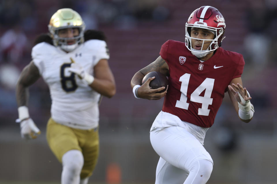 Stanford quarterback Ashton Daniels runs away from Notre Dame linebacker Marist Liufau (8) during the first half of an NCAA college football game in Stanford, Calif., Saturday, Nov. 25, 2023. (AP Photo/Jed Jacobsohn)