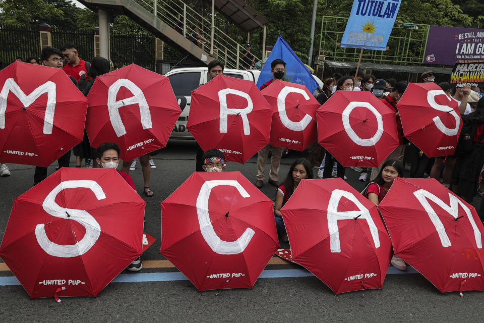 Activists with painted parasols parade on a street during a protest in Quezon City, Philippines, Monday, July 24, 2023, ahead of the second State of the Nation Address of Philippine President Ferdinand Marcos Jr. (AP Photo/Gerard Carreon)