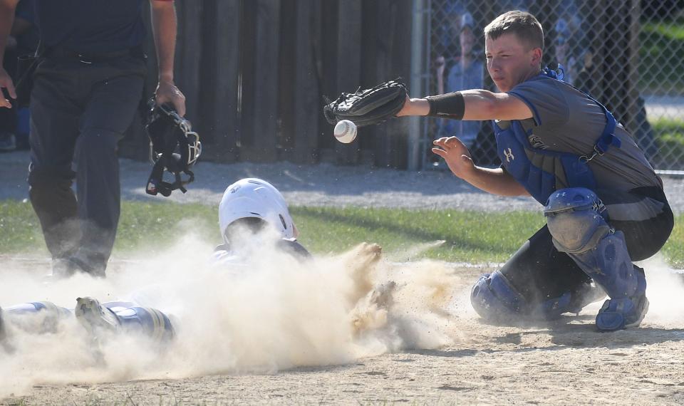 Collins-Maxwell catcher Luke Huntrods (7) catches a throw as Don Bosco's Andrew Kimball (12) slides home for a score during the first inning of the Spartans' 16-3 loss to the Dons June 27 at the Collins City Park baseball field, Monday, June 27, 2022, Iowa.