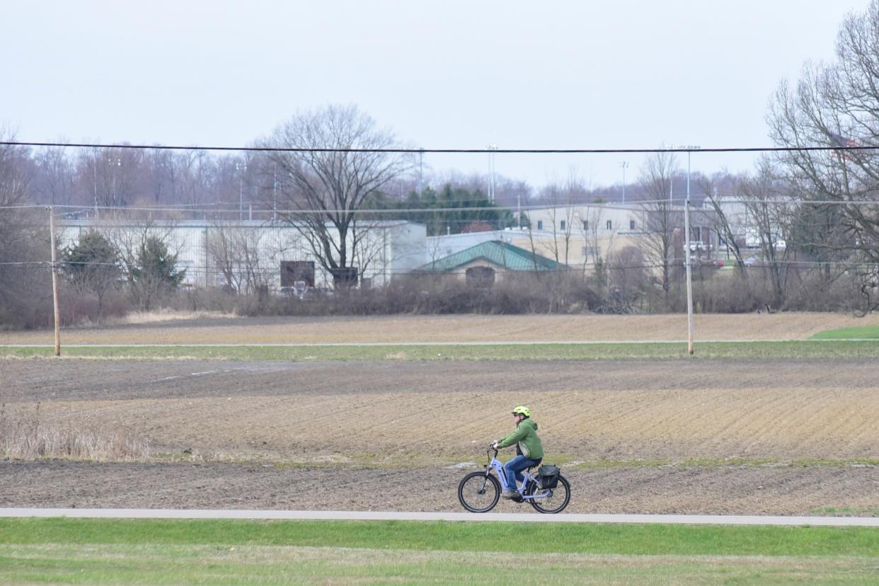 A biker rides past a field on the north side of Galion under sunny skies Monday morning.