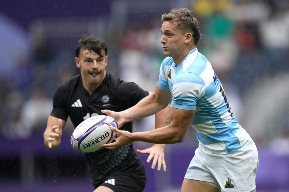 Argentina's Santiago Mare, left, passes the ball under pressure from New Zealand's Leroy Carter (AP)