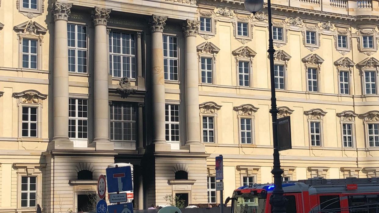 Ein Feuerwehrfahrzeug steht vor dem Berliner Humboldt Forum. Teile der Fassade sind schwarz vom Ruß.