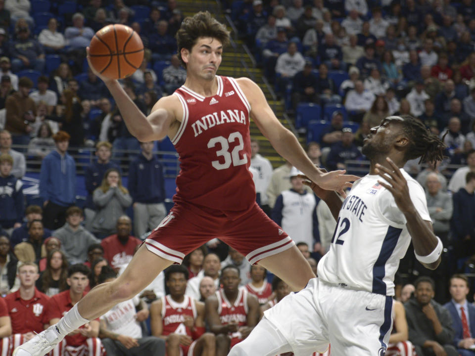 Indiana's Trey Galloway (32) saves the ball from going out of bounds as Penn State's Favour Aire, right, defends during the first half of an NCAA college basketball game Saturday Feb. 24, 2024, in State College, Pa. (AP Photo/Gary M. Baranec)