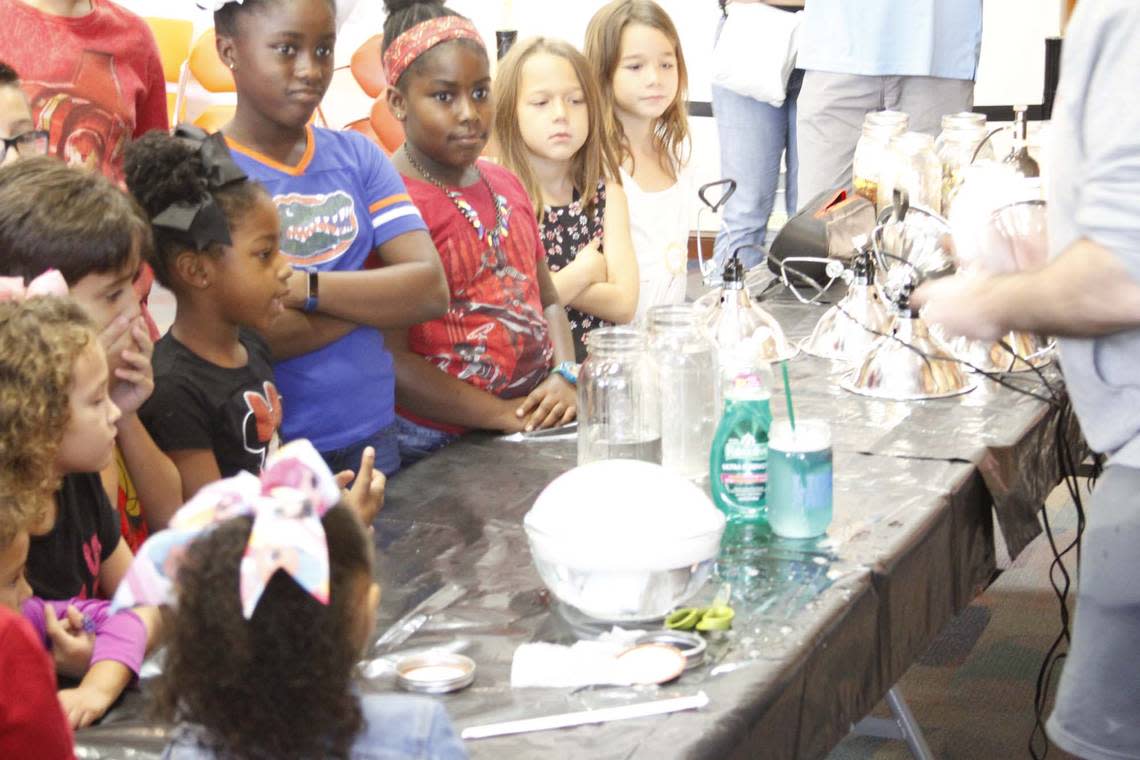 Students at a Manifezt Foundation STEM event engage in creating a biosphere and observing the greenhouse effect at the Coral Gables Library in September 2018.