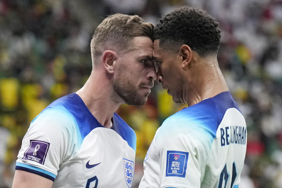 Jordan Henderson (izquierda) celebra con Jude Bellingham tras anotar el primer gol de Inglaterra en el partido contra Senegal por los octavos de final del Mundial, el domingo 4 de diciembre de 2022, en Jor, Qatar. (AP Foto/Hassan Ammar)