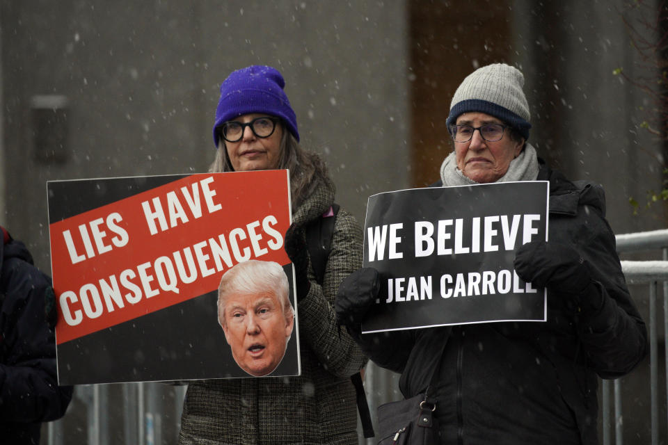 People carry anti-Trump signs outside federal court, in New York, Tuesday, Jan. 16, 2024, the venue for the E. Jean Carroll's case against Donald Trump to determine how much more he owes the writer for denying that he sexually assaulted her in the 1990s and accusing her of lying about her claims. (AP Photo/Eduardo Munoz Alvarez)