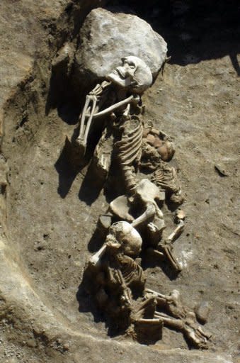 This handout photo, provided by the Bulgarian National Institute of Archeology, shows the remains of a man and two children in the necropolis of a small settlement made of two-story houses near the town of Provadia in eastern Bulgaria. Archeologists have uncovered the remains of what could be the oldest prehistoric city in Europe founded around a salt mine and dating back to the 5th millennium BC