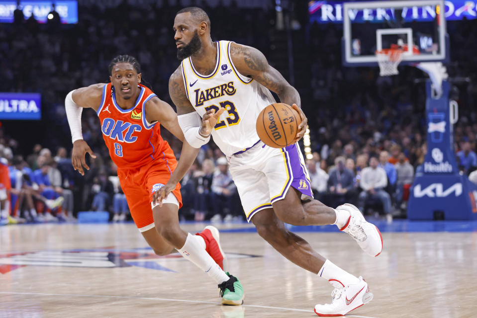 El alero de los Lakers de Los Ángeles LeBron James avanza con el balón superando al alero del Thunder de Oklahoma City Jalen Williams en el encuentro del sábado 23 de diciembre del 2023. (AP Foto/Nate Billings)