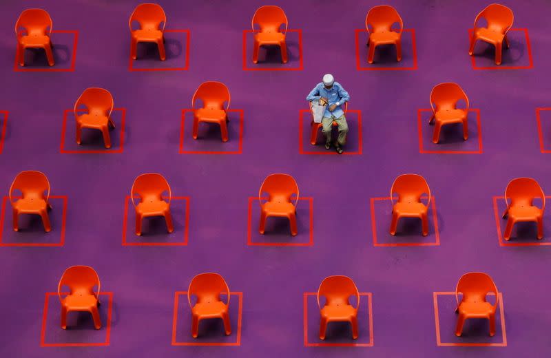 A man sits amongst empty seats at a free movie screening as restrictions on social gathering are tightened due to the surge of cases in the coronavirus disease (COVID-19) outbreak, in Singapore